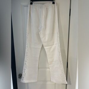 White linen pants with beautiful side lace detail that goes up 3/4 of the leg.